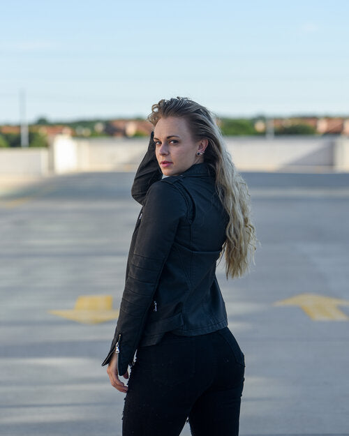 Woman wearing a black leather jacket in an outdoor setting,for her branding.